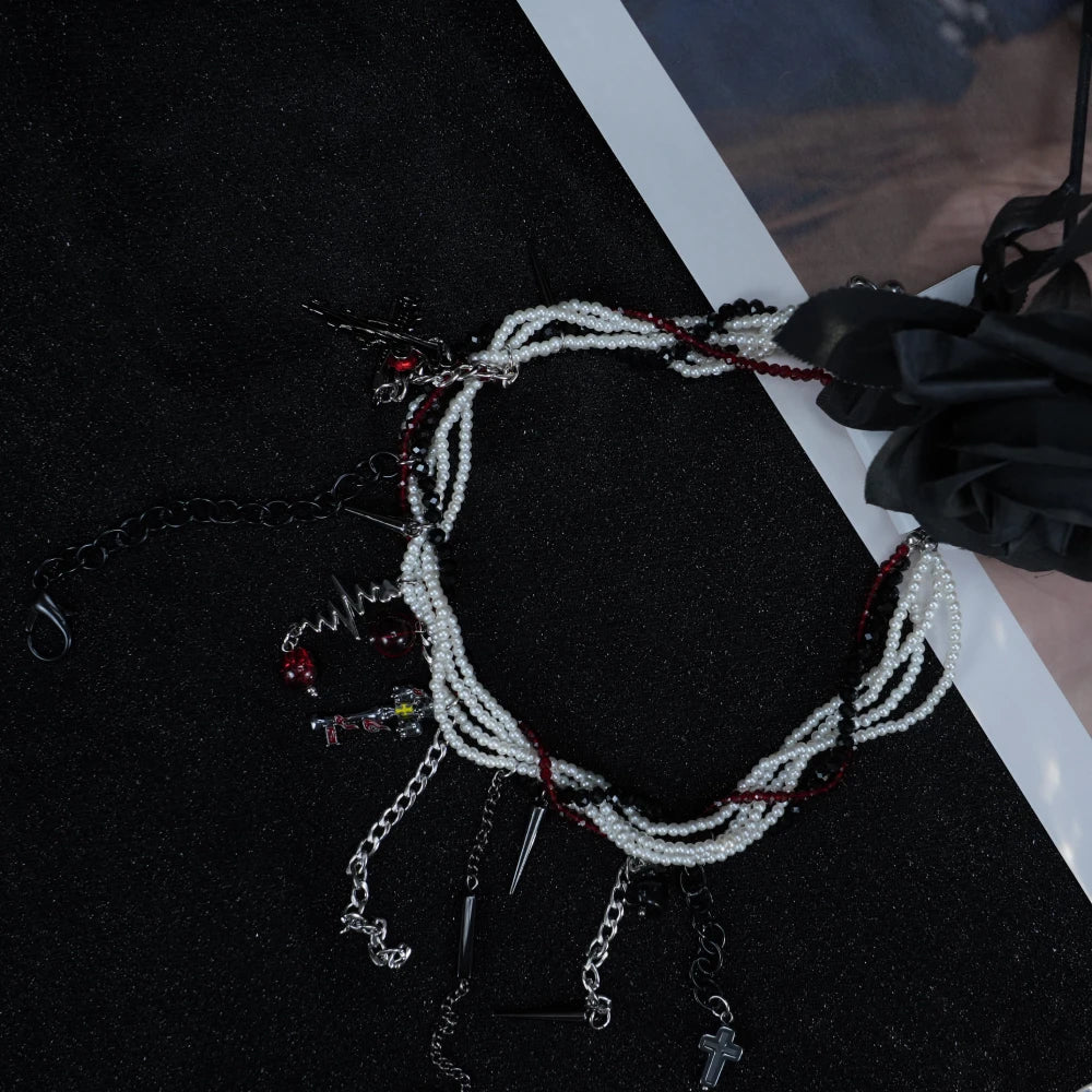 Collana gotica a strati con perline Y2K, punte, ciondoli a croce e accenti di gemme rosse